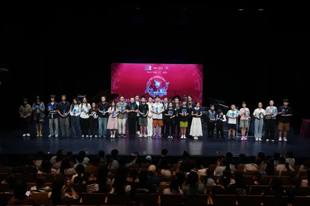 Young participants standing together across a concert-hall stage
